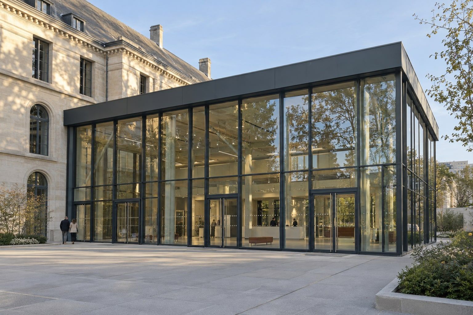 Extension vitrée à ossature aluminium accolée à un bâtiment en pierre